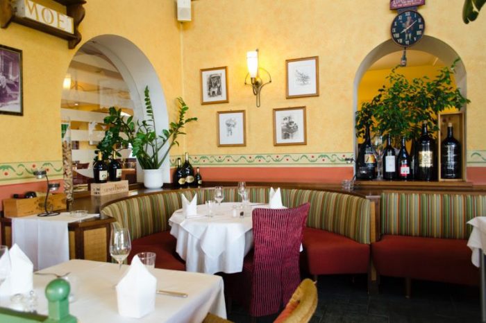 Lichterfüllter Restaurant-Wintergarten mit hohen Decken und festlich gedeckten Tischen