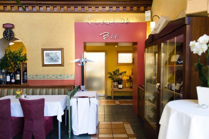 Lichterfüllter Restaurant-Wintergarten mit dem Zugang zur Bar und Veranda