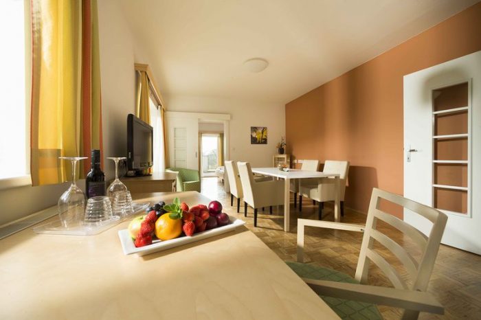 Geräumige Hotelsuite 201 in der Südsteiermark mit Wohnzimmer, Essbereich und Schlafzimmer mit Doppelbett.