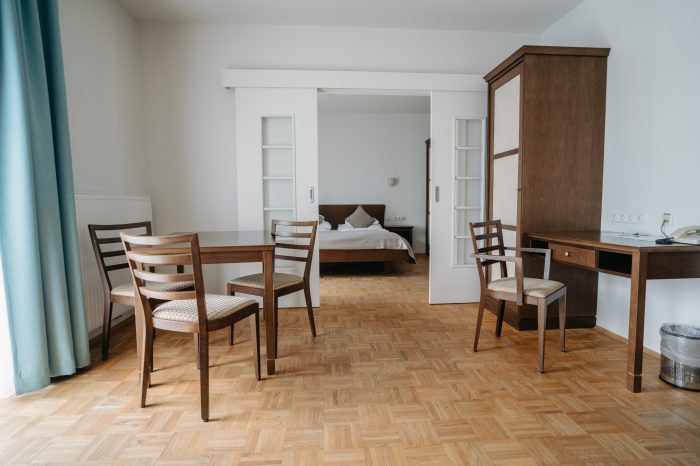 Helle und moderne Hotelsuite in der Südsteiermark mit Doppelbett, Sitzbereich und TV.