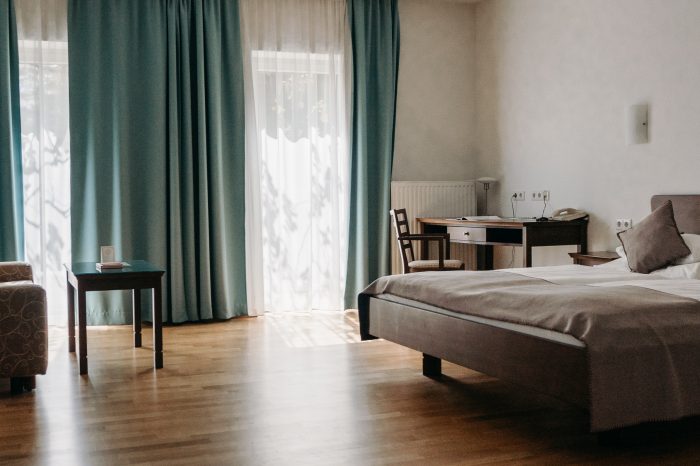 Helles und modernes Hotelzimmer Weinland (barrierefrei) in der Südsteiermark mit Doppelbett, Sitzbereich und TV.